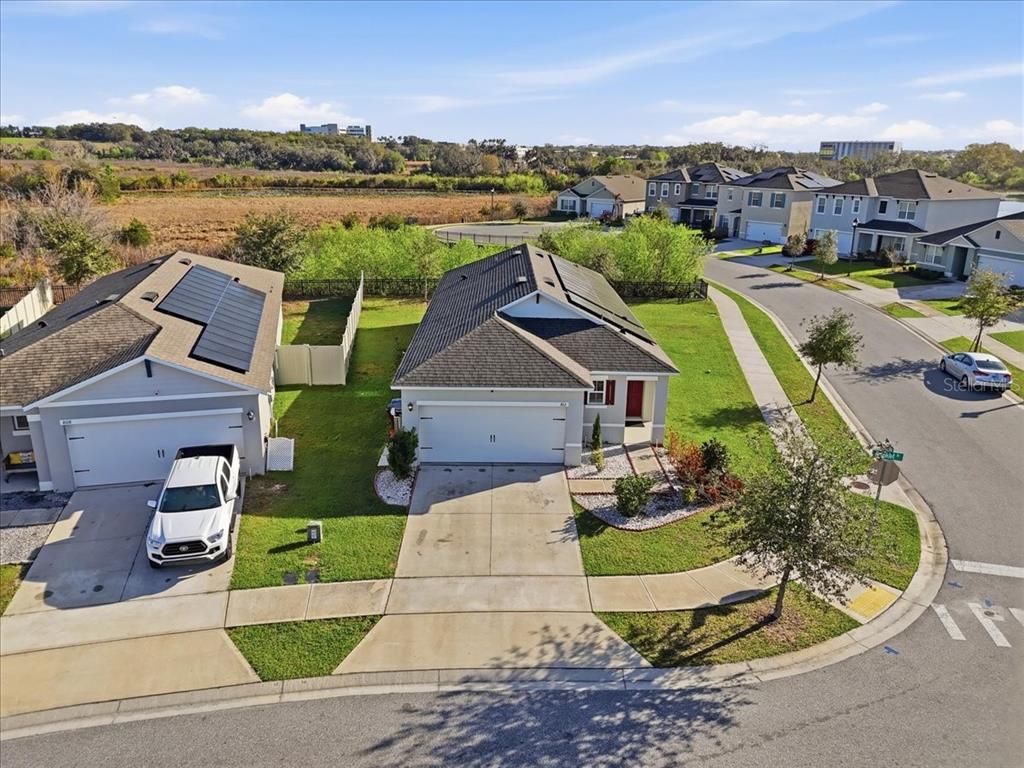 An aerial view shows two suburban houses with driveways and solar panels on a street — 812 BROOKLET DRIVE, DAVENPORT, FL