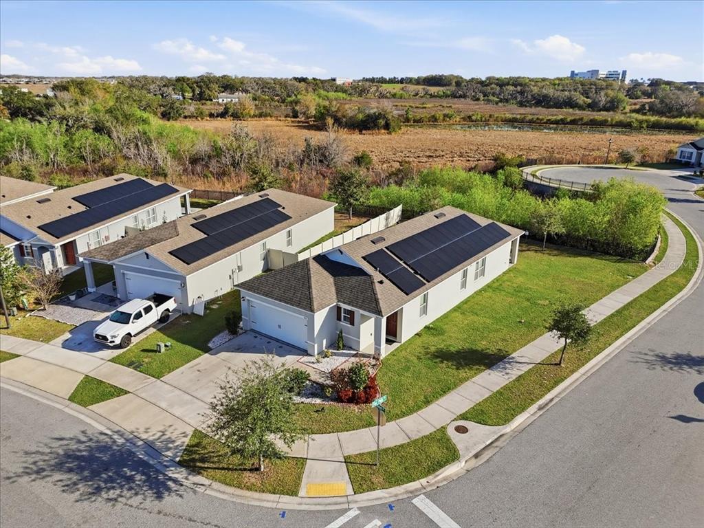 An aerial view shows two adjacent suburban houses with solar panels on their roofs — 812 BROOKLET DRIVE, DAVENPORT, FL