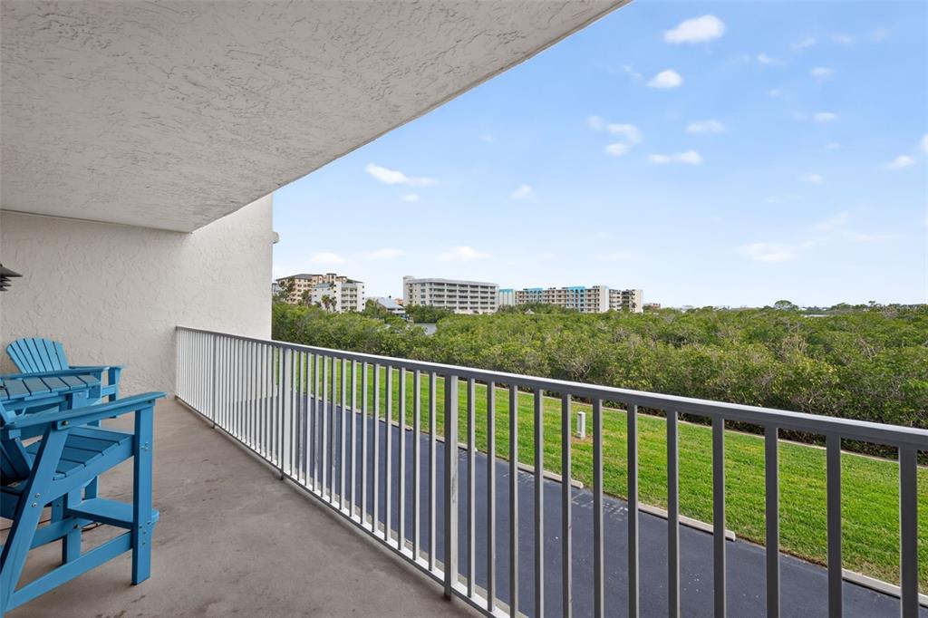 An aerial view shows a large multi-story apartment building with a pool and boat docks — 19451 GULF BOULEVARD UNIT 204, INDIAN SHORES, FL