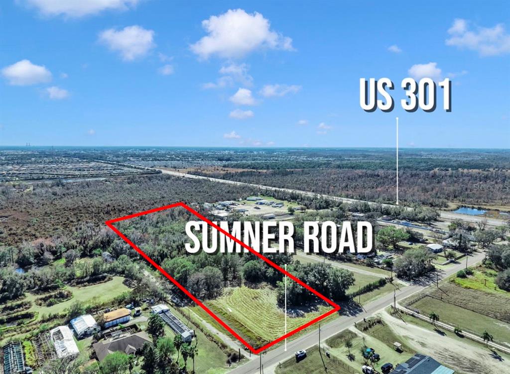 An aerial view shows a vacant, rectangular lot outlined in red along a paved road — 10611 SUMNER ROAD, WIMAUMA, FL