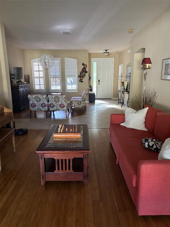 A living room features a red sofa, a wooden coffee table, and a dining area — 307 CARRIAGE OAK PL, SEFFNER, FL