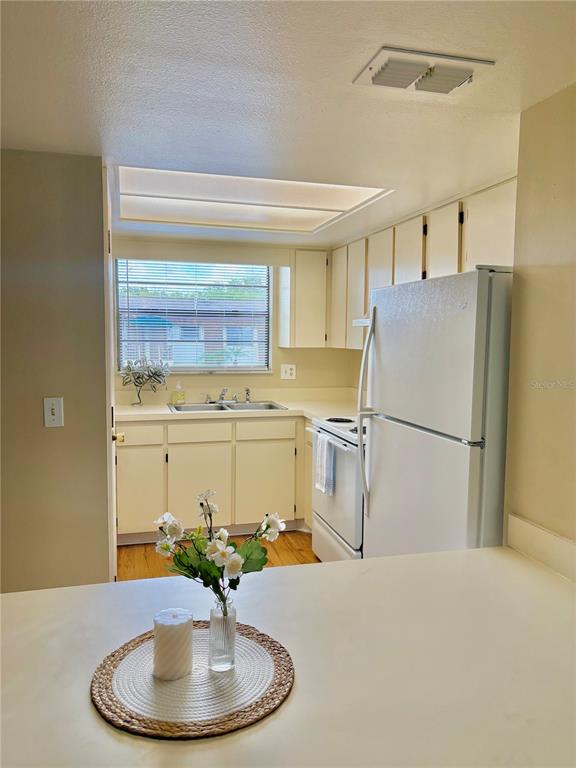 A kitchen with white cabinets, a white refrigerator, and a window above the sink — 6128 TOPHER TRAIL UNIT 6128, MULBERRY, FL