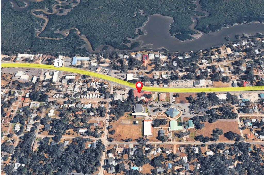 This aerial map view shows a property marked with a pin along US Highway 1 — 1042 N DIXIE FREEWAY, NEW SMYRNA BEACH, FL