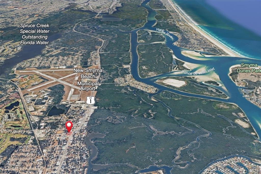 This is an aerial map view showing New Smyrna Beach, the municipal airport, and surrounding waterways — 1042 N DIXIE FREEWAY, NEW SMYRNA BEACH, FL