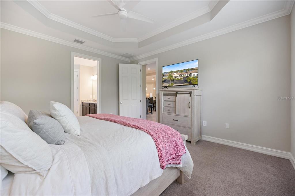 A bedroom features a bed with a pink throw, a dresser with a television, and carpet — 520 MARAVIYA BOULEVARD, NOKOMIS, FL