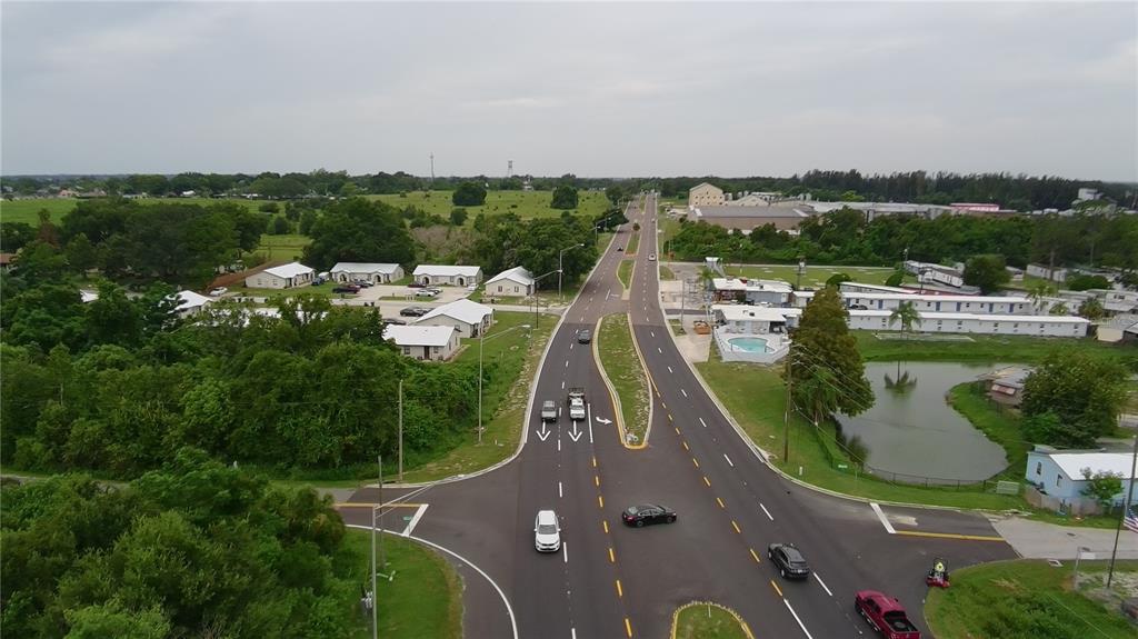 An aerial view shows a dense, wooded lot situated next to a lake and road — 0 ALFRED DRIVE E, LAKE ALFRED, FL