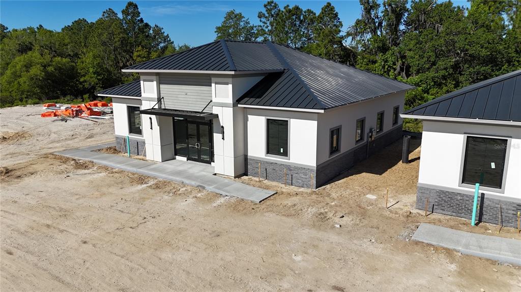 An exterior view of a modern commercial building with a metal roof and stone accents — 60 EXCHANGE LOOP LOOP UNIT 4, PALM COAST, FL