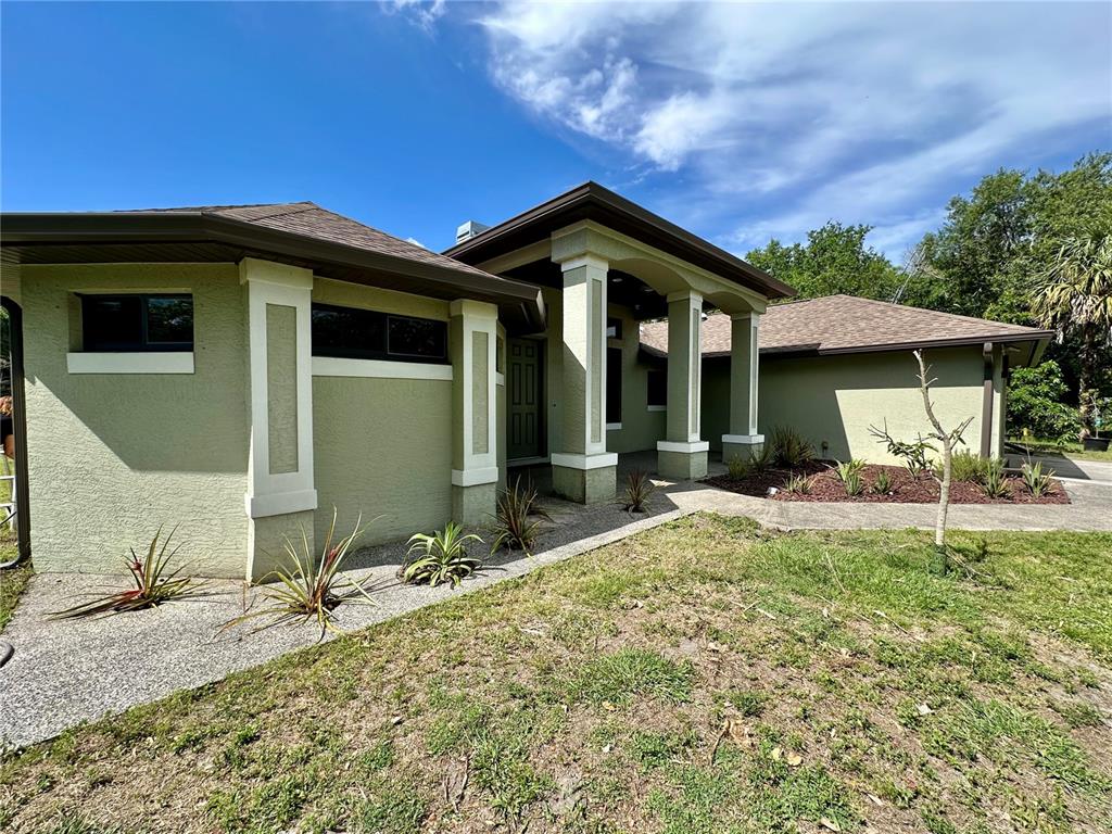 A single-story house with a beige stucco exterior, a two-car garage, and a concrete driveway — 7759 ESTATES DRIVE, NORTH PORT, FL