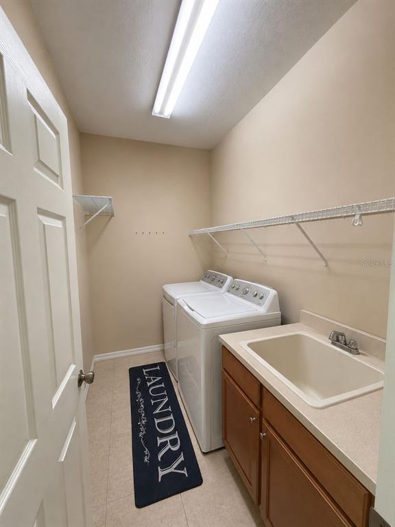 A laundry room with a white washer and dryer, a utility sink, and wire shelving — 11505 52ND COURT E, PARRISH, FL