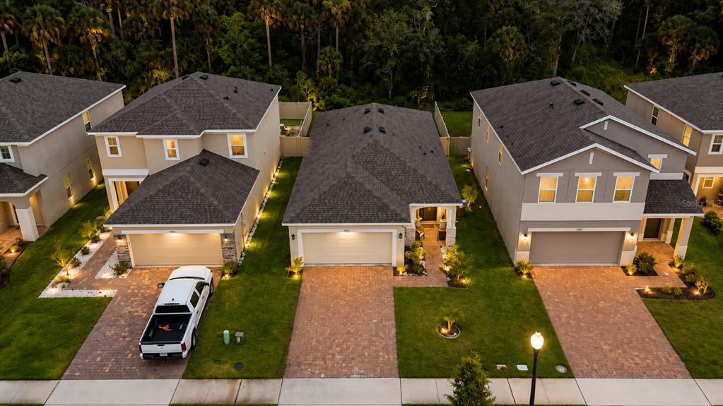 A kitchen features white cabinets, stainless steel appliances, granite countertops, and a dark herringbone backsplash — 5003 ROYAL POINT AVENUE, KISSIMMEE, FL
