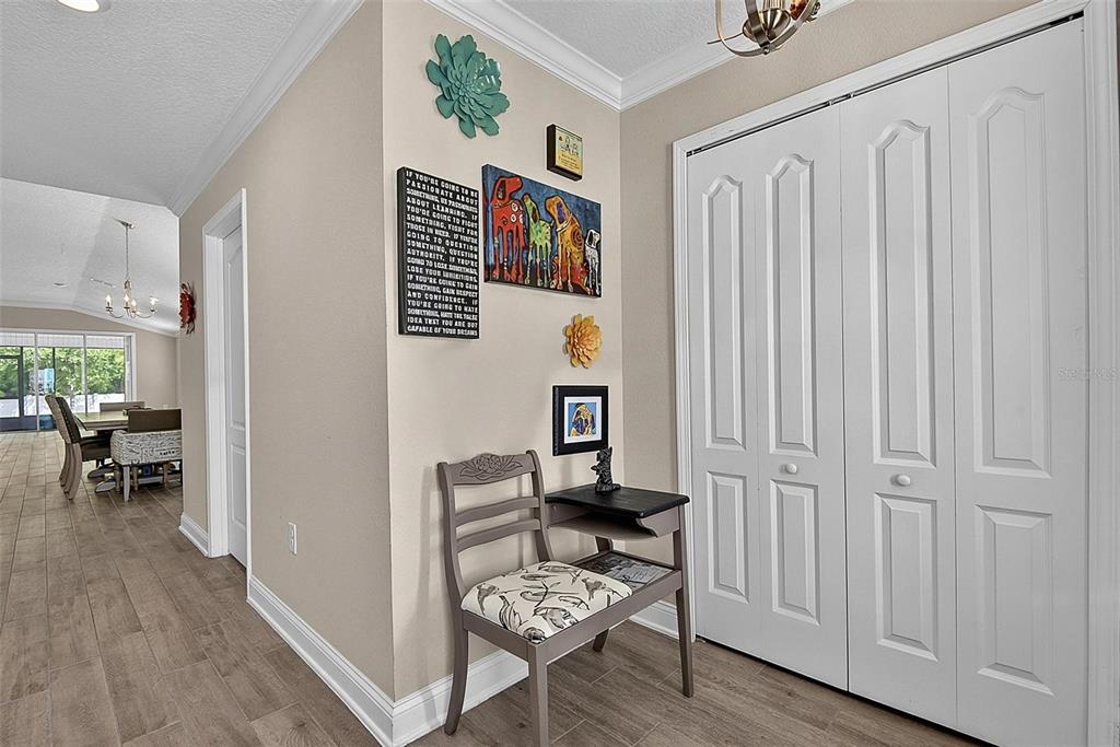 A hallway features a wooden chair, wall art, and white bi-fold closet doors — 425 NARVAREZ AVENUE, ST AUGUSTINE, FL