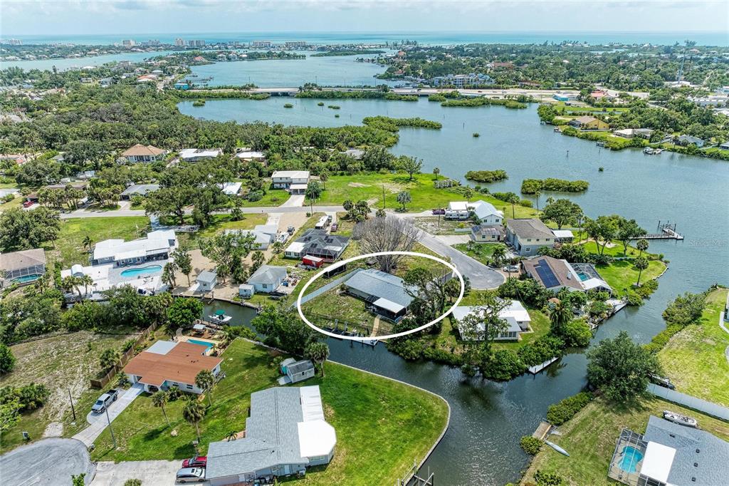 An aerial view shows a residential property with a house circled on a waterfront lot — 302 DONA DRIVE, NOKOMIS, FL
