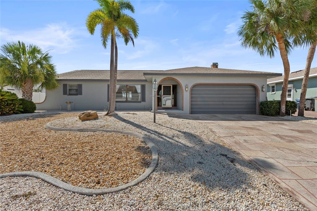 A single-story house with a gray exterior, a gravel front yard, and two palm trees — 921 BIRDIE WAY, APOLLO BEACH, FL