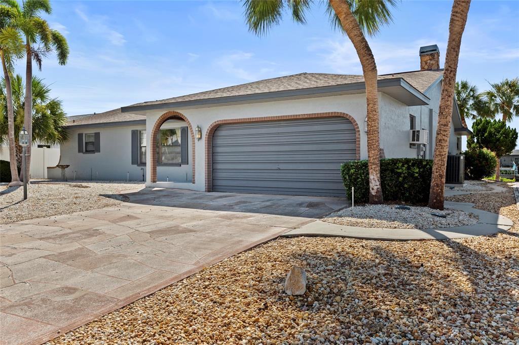 A living room with light wood-look flooring, a grey sofa, and a view of a pool — 921 BIRDIE WAY, APOLLO BEACH, FL