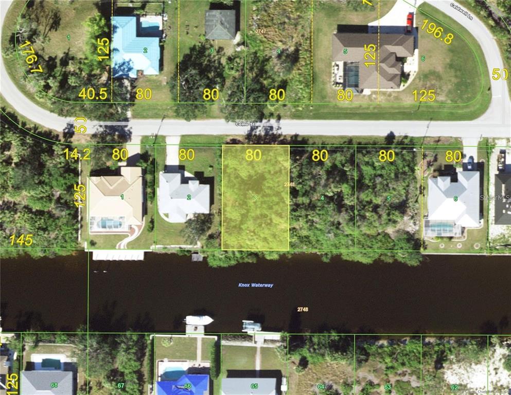 This is an aerial map showing a vacant residential lot highlighted in yellow along a waterway — 3604 COMO STREET, PORT CHARLOTTE, FL
