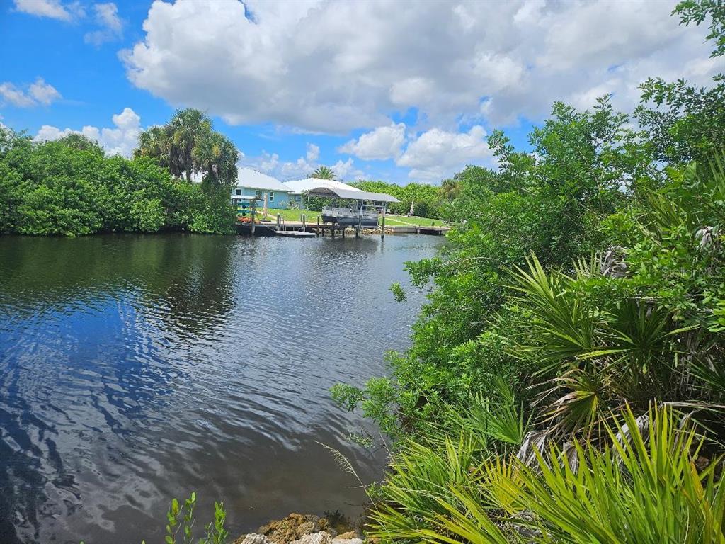 A view of a canal with a boat dock and lift near a residential property — 3604 COMO STREET, PORT CHARLOTTE, FL