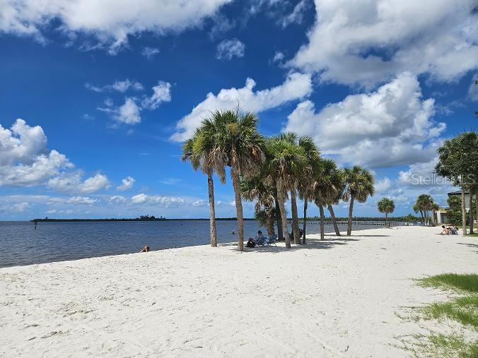 A sandy beach with palm trees along the water under a blue sky with clouds — 3604 COMO STREET, PORT CHARLOTTE, FL
