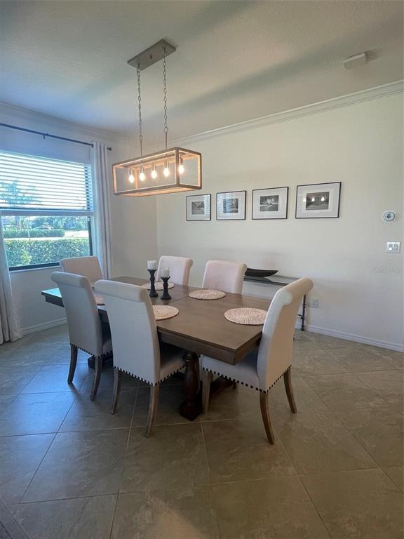 A dining room features a wooden table, upholstered chairs, and a rectangular pendant light fixture — 531 FIRE BUSH COURT, BRADENTON, FL
