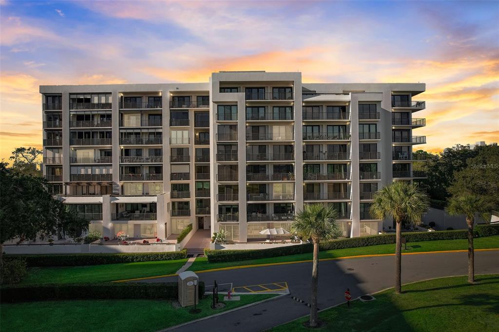 A multi-story residential apartment building with balconies stands behind a paved driveway and lawn — 6 BELLEVIEW BOULEVARD UNIT 101, BELLEAIR, FL