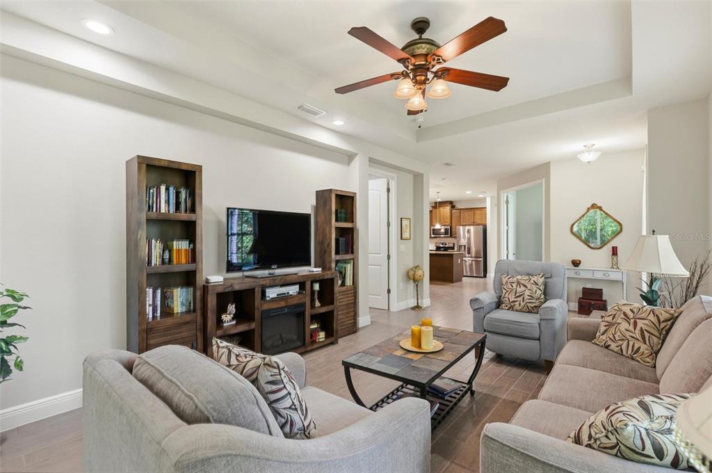 A living room with light gray furniture, a wooden media console, and a ceiling fan — 46 HERON WING DRIVE, ORMOND BEACH, FL