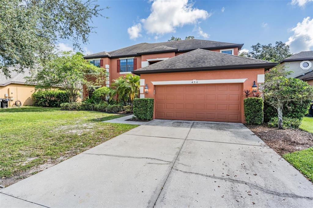 A two-story house with a terracotta-colored exterior and a two-car garage — 456 OAK LANDING BOULEVARD, MULBERRY, FL