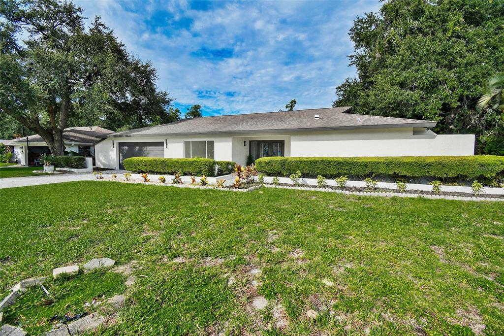 A screened-in patio features a kidney-shaped swimming pool and light-colored tile flooring — 207 DUNBRIDGE DRIVE, PALM HARBOR, FL