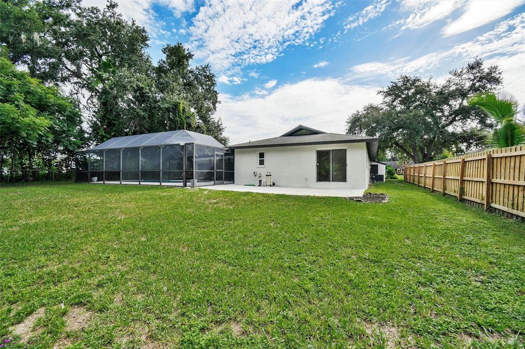 A living room features a marble fireplace, gray armchairs, a sectional sofa, and a ceiling fan — 207 DUNBRIDGE DRIVE, PALM HARBOR, FL