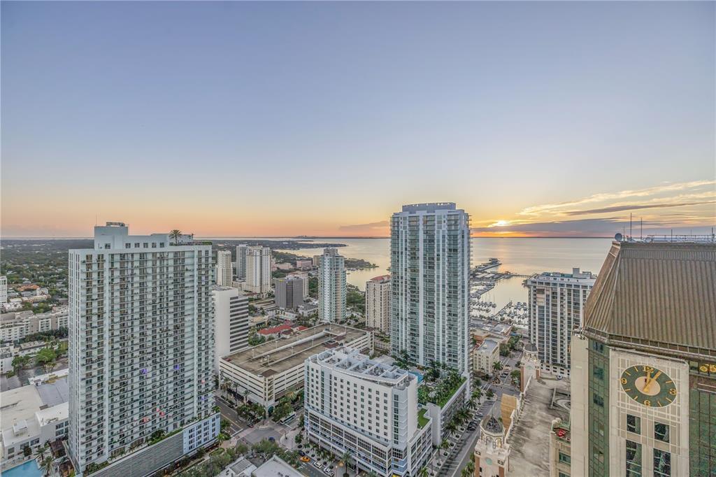 An elevated view of a city skyline at sunset overlooking a bay with multiple skyscrapers — 275 1ST AVENUE S UNIT 3704, ST PETERSBURG, FL