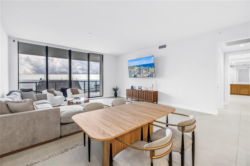 A modern living and dining area with floor-to-ceiling windows overlooking the ocean — 275 1ST AVENUE S UNIT 3704, ST PETERSBURG, FL