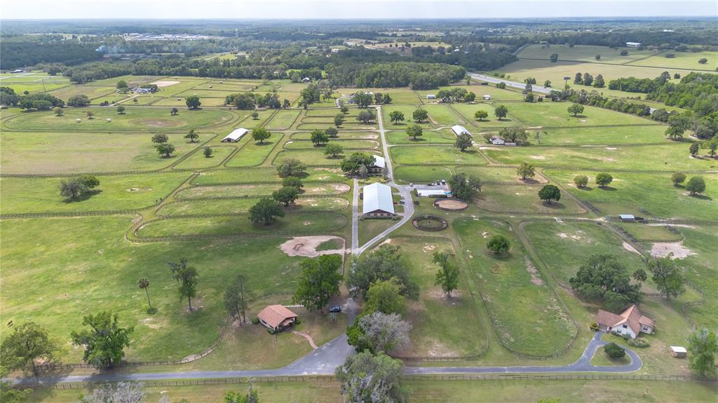 An aerial view of a large horse farm with multiple pastures, barns, and two houses — 5100 W HWY 329, REDDICK, FL