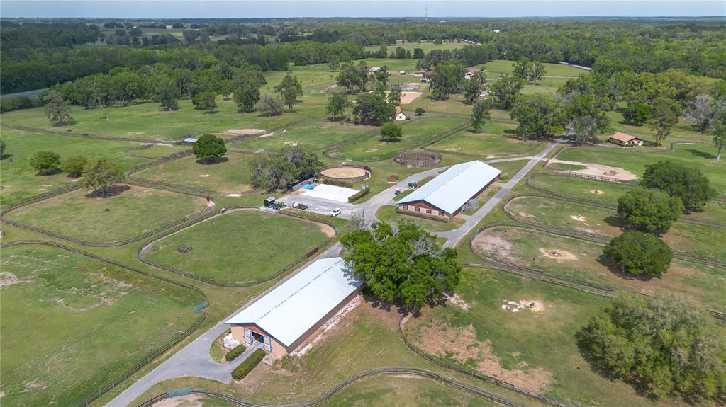 An aerial view of a rural horse farm featuring multiple fenced pastures and two barns — 5100 W HWY 329, REDDICK, FL