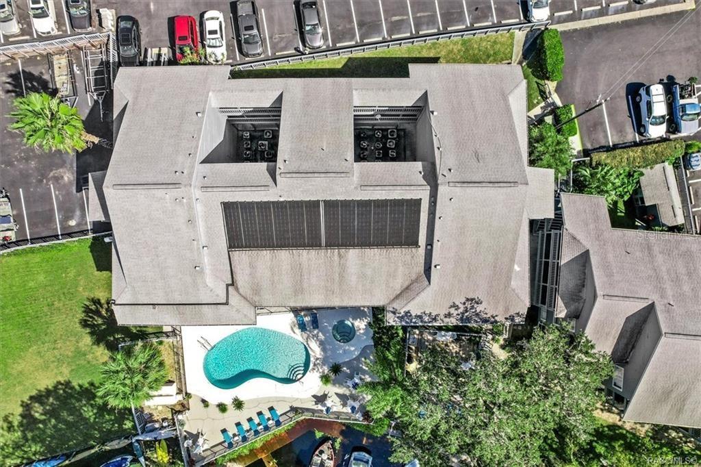 An aerial view shows a multi-story building with a pool, solar panels, and parking lot — 20820 RIVER DRIVE UNIT B37, DUNNELLON, FL