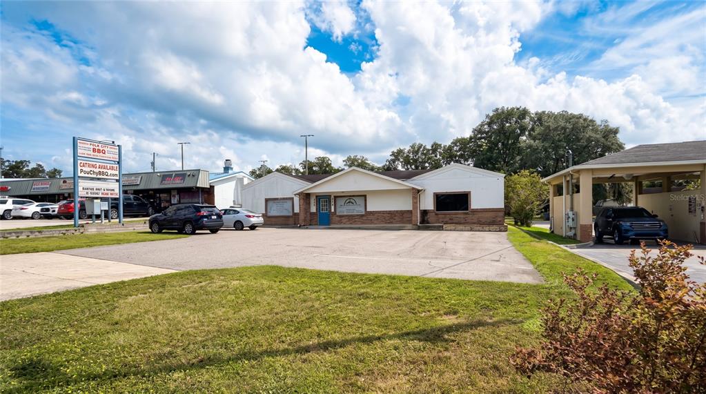 A single-story commercial building with a parking lot and three parked cars — 223 COMMONWEALTH AVENUE SW, POLK CITY, FL