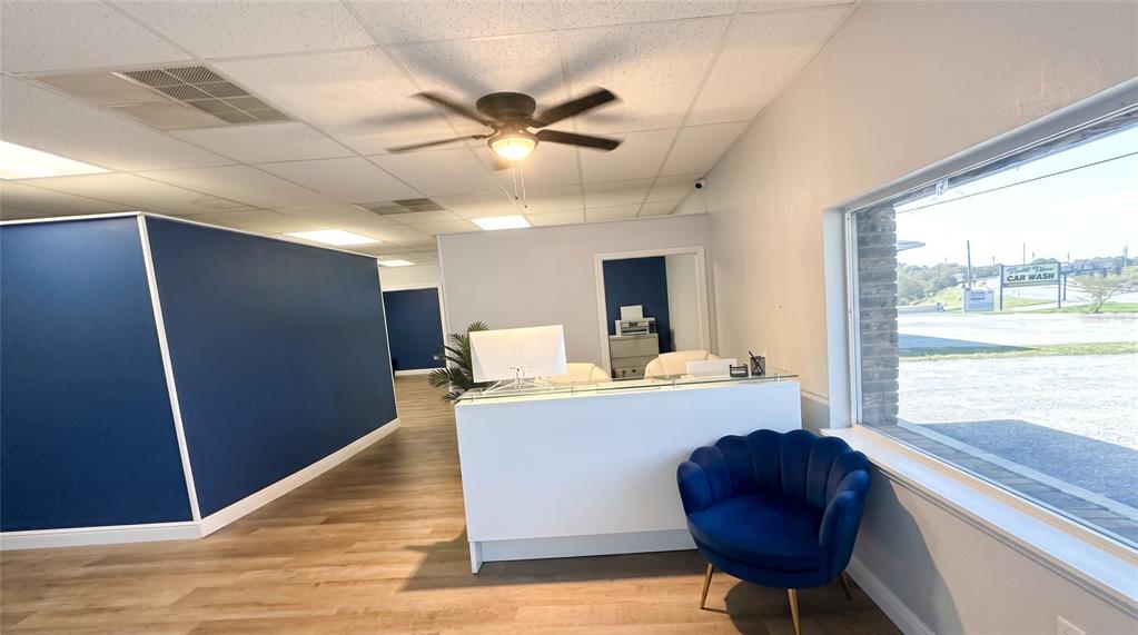 A breakroom features a kitchenette with white cabinets, a dark blue wall, and seating area — 223 COMMONWEALTH AVENUE SW, POLK CITY, FL