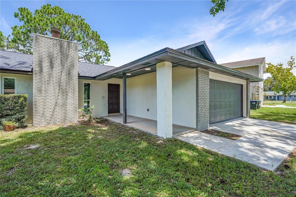 A single-story house exterior features a brick chimney, a covered entryway, and an attached garage — 3336 TCU BOULEVARD, ORLANDO, FL