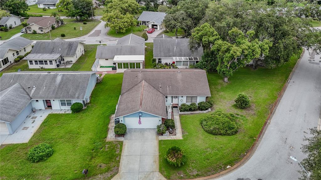 An aerial view shows a suburban house with a gray roof and a concrete driveway — 8045 PASADENA DRIVE, PORT RICHEY, FL