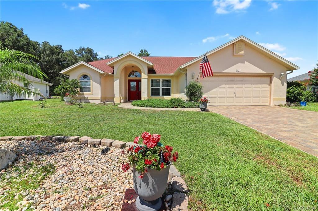 A single-story house with a tan exterior, red roof, and a paved driveway — 3640 E HIDDEN COVE TRAIL, HERNANDO, FL