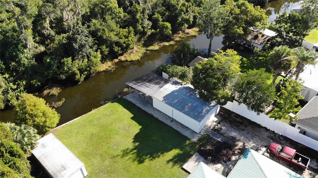 A single-story house with a teal metal roof and white exterior sits on a lawn — 5329 EAGLES NEST ROAD, FRUITLAND PARK, FL