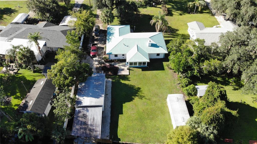 A single-story house with a turquoise roof, a concrete driveway, and a detached garage — 5329 EAGLES NEST ROAD, FRUITLAND PARK, FL