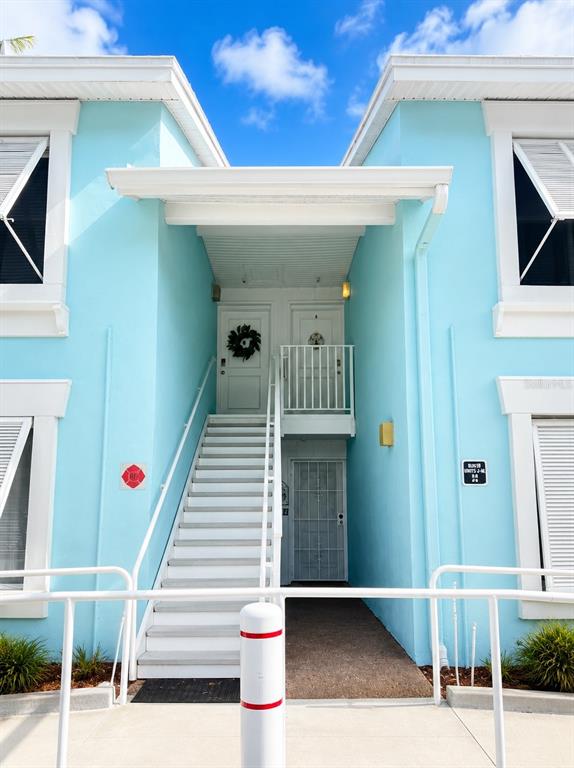 An exterior view of a light blue building with a central staircase leading to two doors — 3730 42ND WAY S UNIT H, ST PETERSBURG, FL