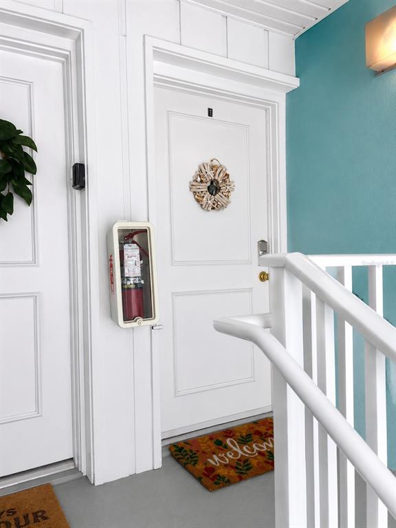 A white door with a wreath and a fire extinguisher mounted on the adjacent wall — 3730 42ND WAY S UNIT H, ST PETERSBURG, FL