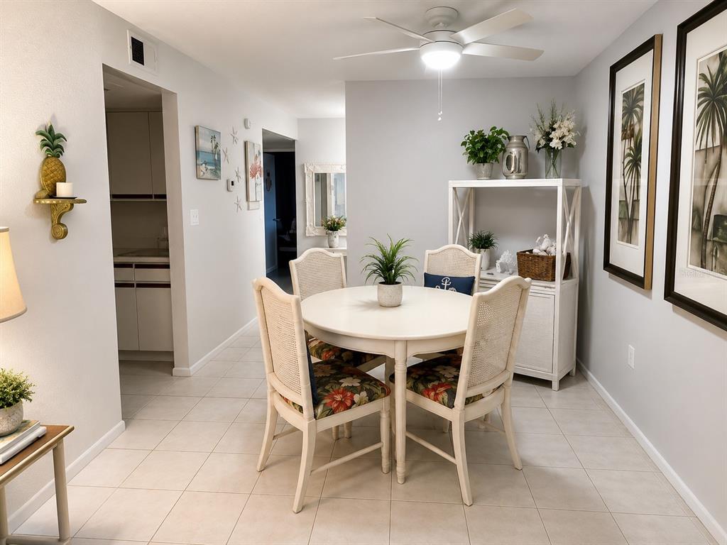A dining area features a round white table, four cane-back chairs, and a white hutch — 3730 42ND WAY S UNIT H, ST PETERSBURG, FL