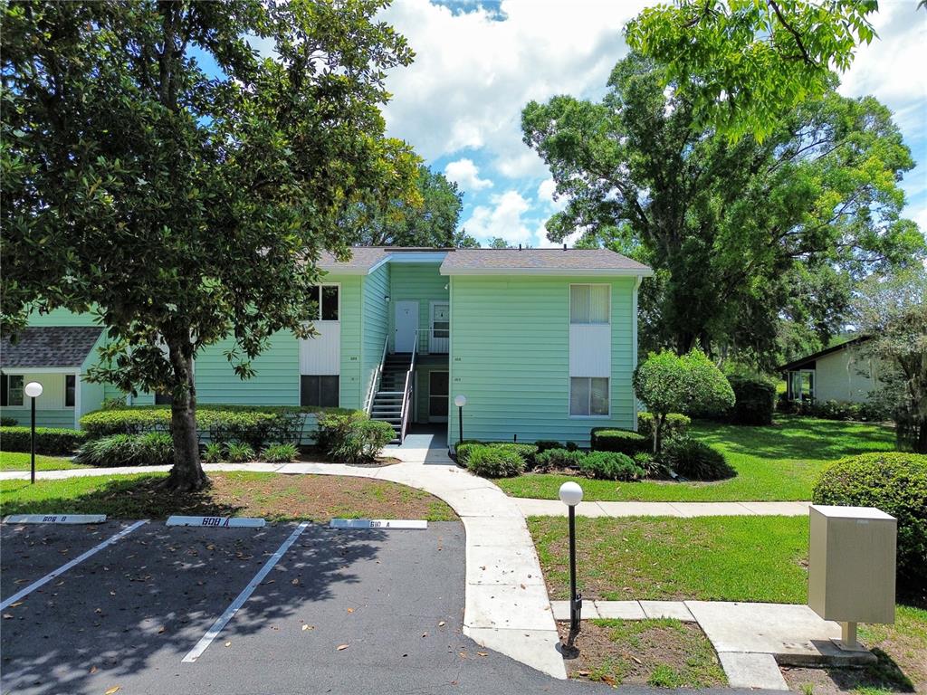 A two-story, light green apartment building with a central staircase and adjacent parking spaces — 608 MIDWAY DRIVE UNIT A, OCALA, FL