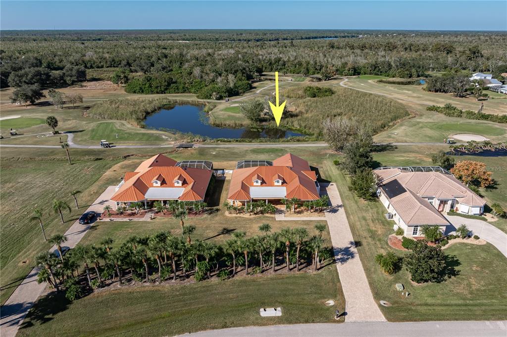 An aerial view shows two houses with orange roofs overlooking a golf course pond — 8289 SW AVIARY ROAD, ARCADIA, FL