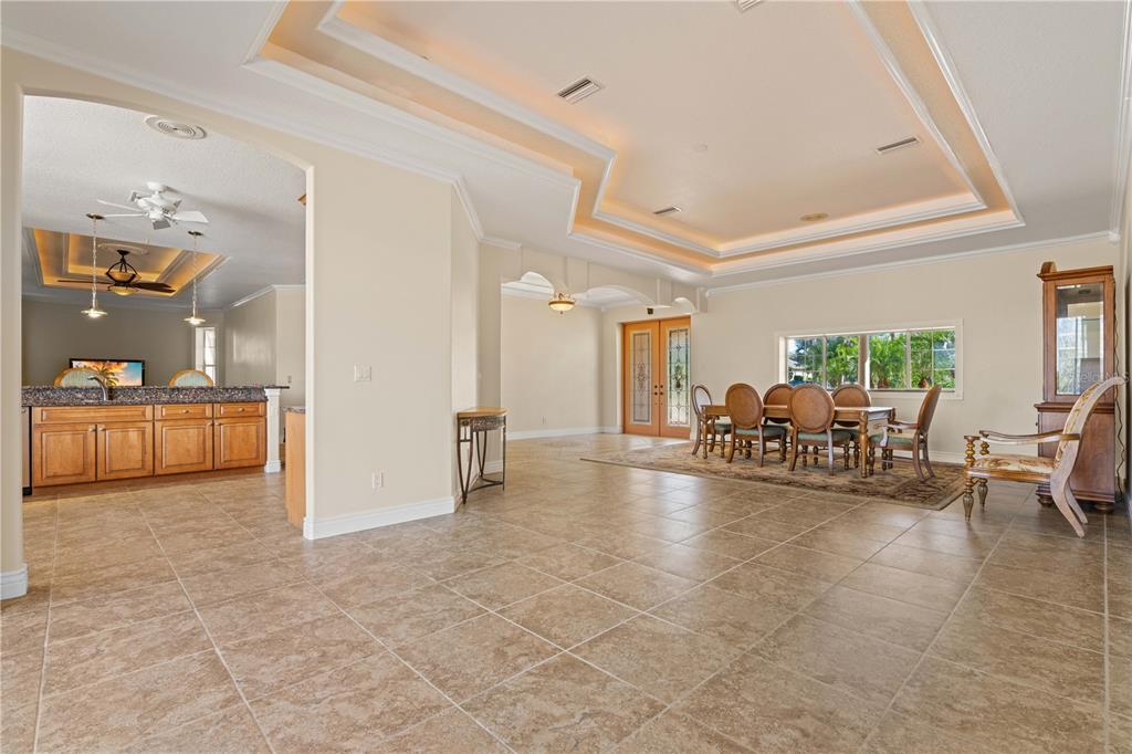 A spacious dining area features tile flooring, a tray ceiling, and a wooden dining set — 8289 SW AVIARY ROAD, ARCADIA, FL