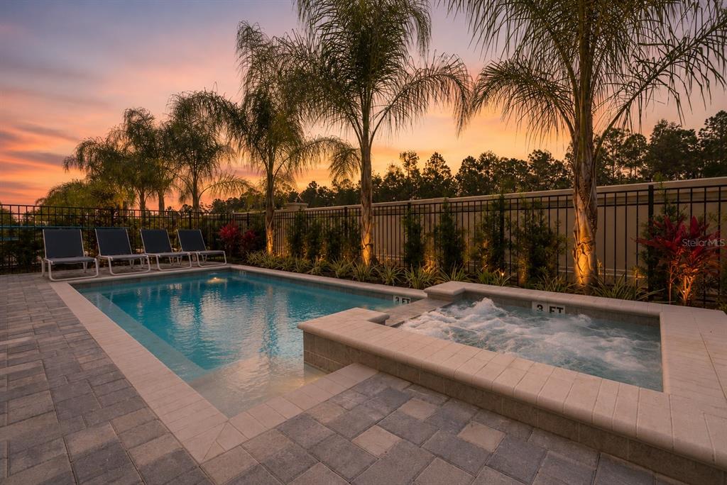 A two-story house with a stone-accented garage, white stucco exterior, and a second-floor balcony — 481 LASSO DRIVE, KISSIMMEE, FL