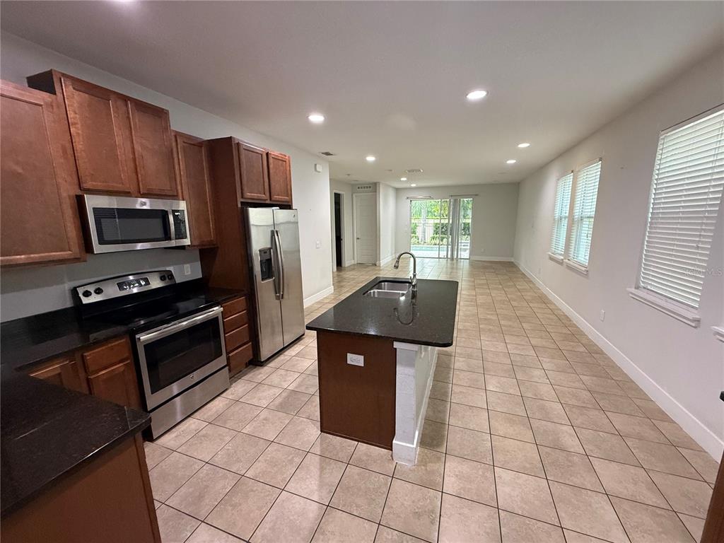 A patio with a dining set overlooks a swimming pool and an attached hot tub — 481 LASSO DRIVE, KISSIMMEE, FL