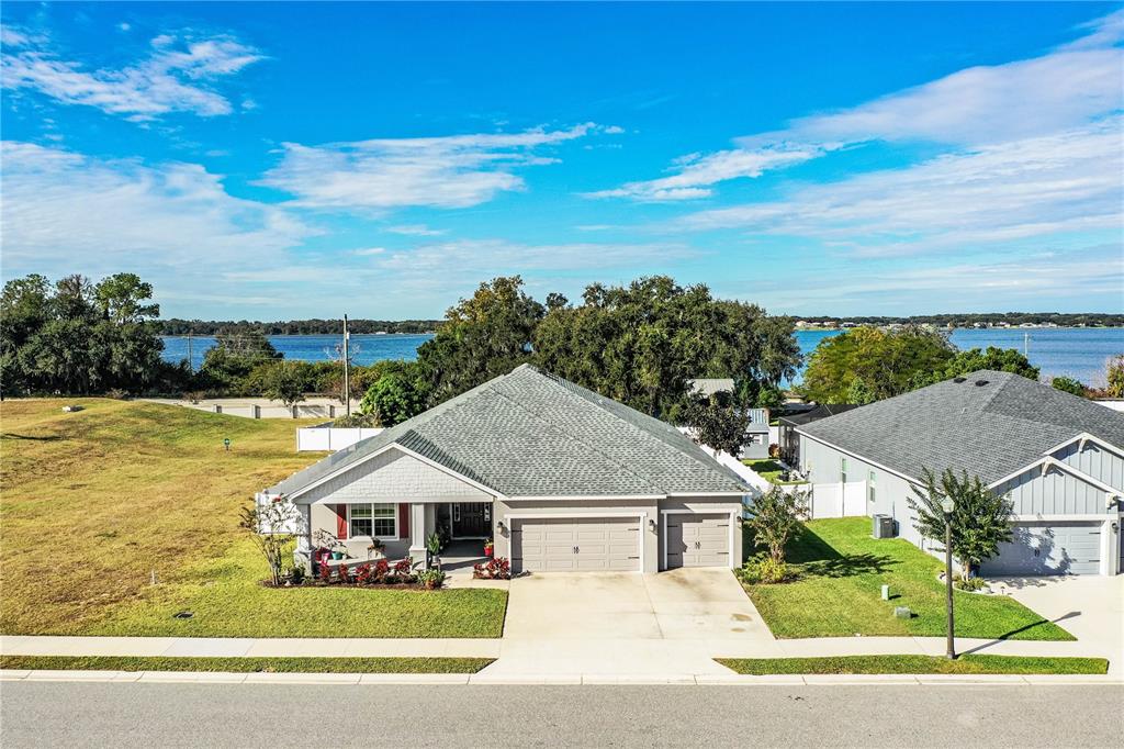A single-story gray house with a three-car garage and a front porch — 261 WALKERS POINT DRIVE, AUBURNDALE, FL