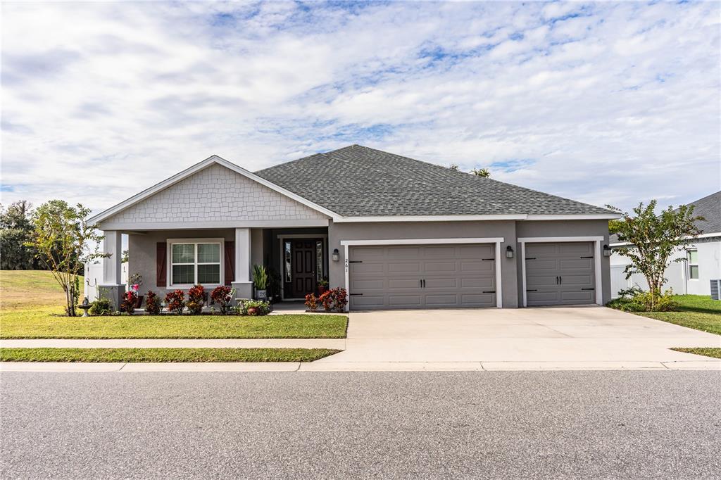A single-story suburban house with a gray exterior, a two-car garage, and a front porch — 261 WALKERS POINT DRIVE, AUBURNDALE, FL
