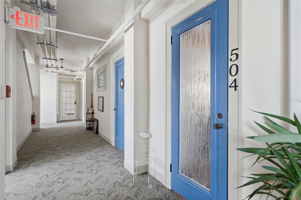 A kitchen features blue cabinets, open wood shelving, a central island, and a white refrigerator — 130 4TH AVENUE N UNIT 504, ST PETERSBURG, FL
